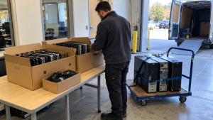 Office computers and boxed laptops staged for an equipment pickup
