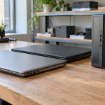 A closed desktop UPS battery backup with a coiled power cord on an office table