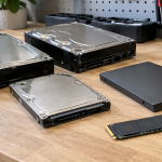 Retired hard disk drives and solid-state drives arranged on an electronics workbench