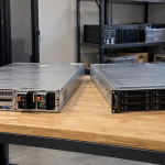 Two rackmount servers resting on an electronics workbench