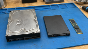 A hard disk drive, an enclosed solid-state drive and an M.2 storage module on a work mat