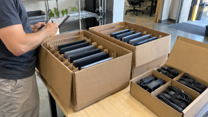 Used business laptops arranged in protective dividers for a bulk equipment handover