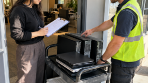 Staff checking computer inventory during recycling collection