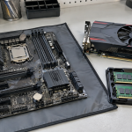 A motherboard, RAM modules and graphics card arranged on an electronics workbench