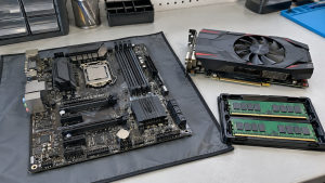 A motherboard, RAM modules and graphics card arranged on an electronics workbench